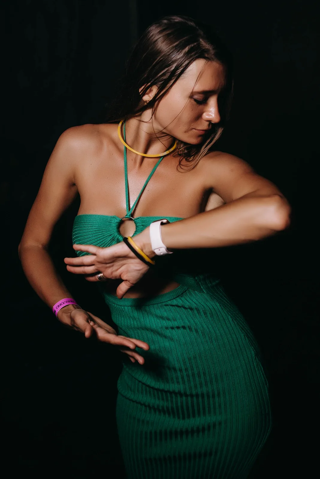 Dancer in a green dress mid-move under club light