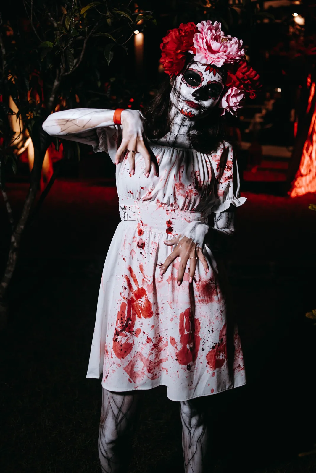 Guest in sugar-skull makeup and floral crown at a Halloween party
