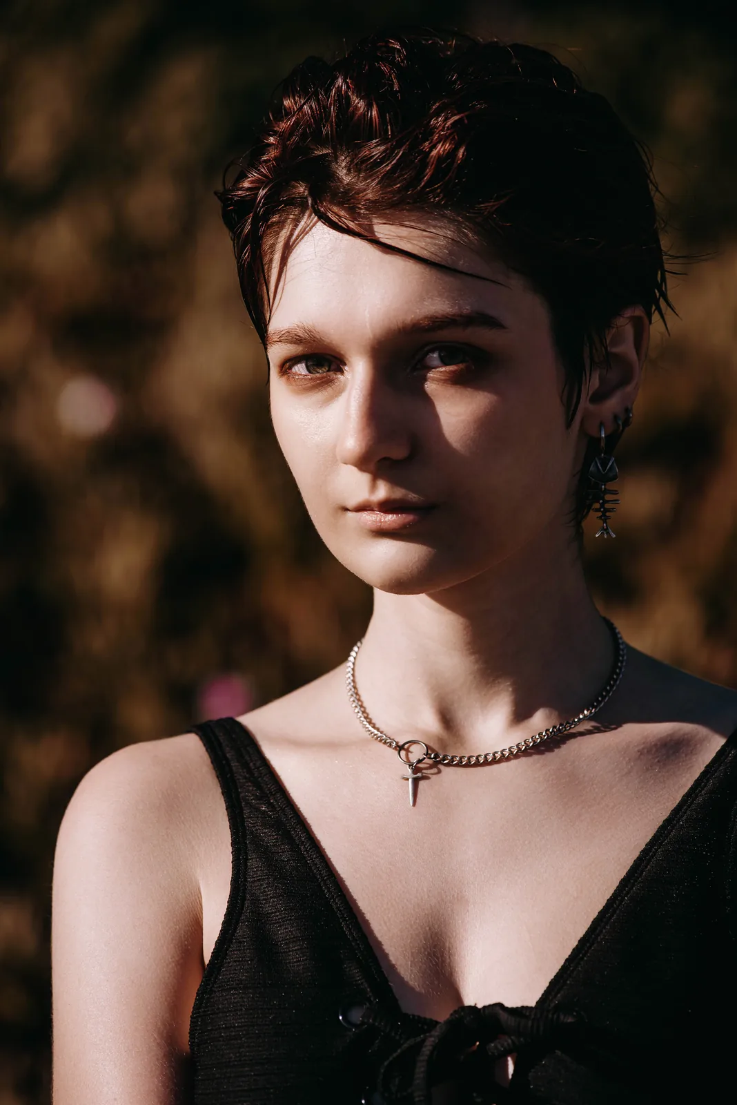 Close portrait of a woman with short hair and a choker, warm low light